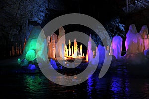 Frozen water Stalagmite in deep marble cave, Russia