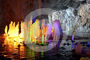 Frozen water Stalagmite in deep marble cave, Russia