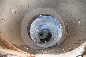 frozen water surface and ice hole in concrete well