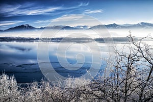 Frozen water surface of lake. Mountains at background