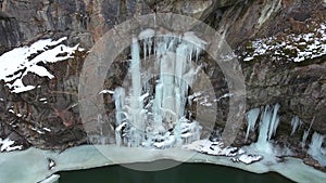 Frozen waterfall in a gorge with a mountain river