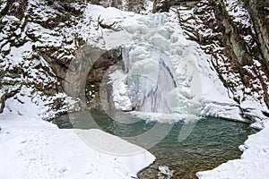 Frozen waterfall in the mountains in winter time ,snow cover