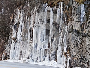 Frozen waterfall plunging from a steep rock cliff
