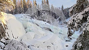 Frozen waterfall on river that`s starting to freeze