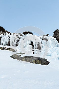 Frozen waterfall Skok in High Tatras Slovakia in winter time. Big waterfall with blue giant icicles frost on the rocks