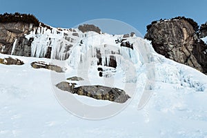 Frozen waterfall Skok in High Tatras Slovakia in winter time. Big waterfall with blue giant icicles frost on the rocks