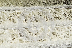 Frozen Waterflow. Water flowing over the rock cascades. Mountain river rapids spring view