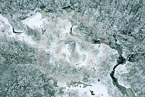 Frozen winding river in snow-covered winter forest. aerial view