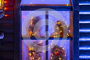 Frozen window with unfocused festive interior inside for decorative design. Holiday celebration