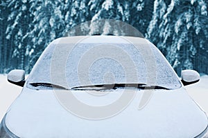 Frozen winter car covered snow, view front window windshield and hood on snowy