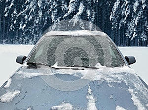 Frozen winter car covered snow, view front window windshield and hood on snowy