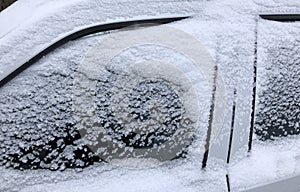 Frozen winter car covered snow, view side window on snowy background