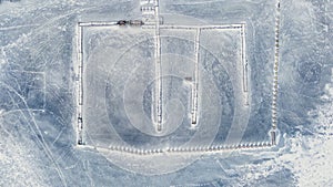 frozen in winter ice lake, docked in pier, aerial top down view