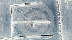 frozen in winter ice lake, docked in pier, aerial top down view