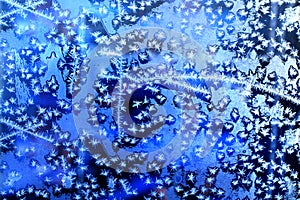 Frozen winter window, glass with frosty patterns, hoarfrost texture, snowflakes, New Year or Christmas ornament for banner