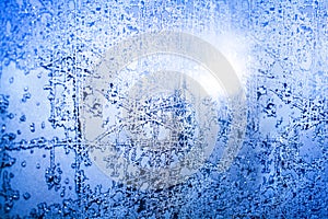 Frozen winter window, glass with frosty patterns, hoarfrost texture, snowflakes, New Year or Christmas ornament for banner