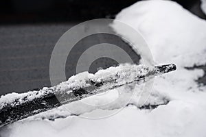 Frozen wiper blade is cover in snow and ice after a snow storm