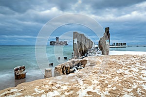 Frozen wooden breakwaters line to the world war II torpedo platform at Baltic Sea