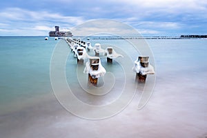 Frozen wooden breakwaters line to the world war II torpedo platform at Baltic Sea