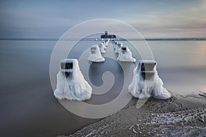 Frozen wooden breakwaters line to the world war II torpedo platform at Baltic Sea