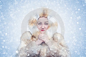 Frozen young woman in a fox fur coat, cold, snow, frost, blizzard