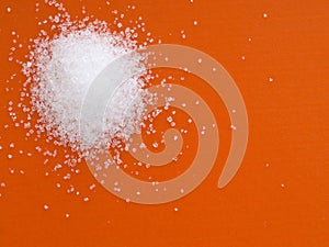 Fructose crystals on orange background.