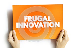 Frugal Innovation is the process of reducing the complexity and cost of a good and its production, text concept on card for