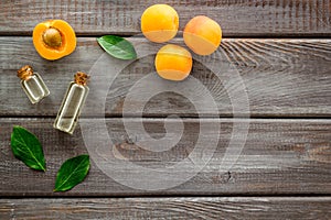 Fruit aroma oil. Apricot kernel oil on dark wooden background top view frame copy space