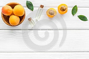 Fruit aroma oil. Apricot kernel oil on white wooden background top view frame copy space