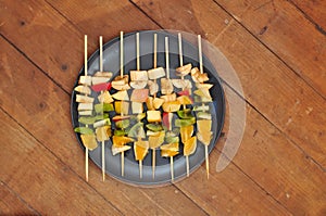 Fruit barbecue on leaf of monstera and wooden background