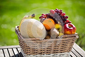 Fruit basket on table, green background