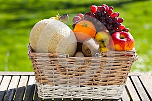 Fruit basket on table, green background