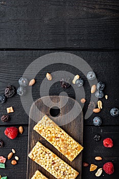 Fruit berry and nut energy bars. Healthy snack, top view with copy space, on black wooden table