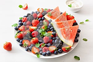 Fruit and berry platter with yogurt over white. blueberry, straw