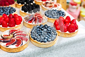 Fruit and berry tarts dessert tray assorted outdoors