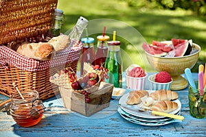 Fruit, bread, honey and ice cream on picnic table