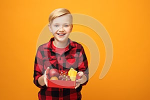 Fruit breakfast for school, a smiling child is holding a box of colorful fresh fruit.