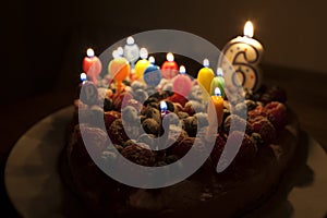 A fruit cake with candles for a sixth birthday.
