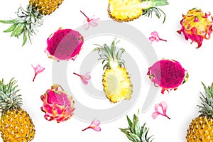 Fruit composition of pineapple and dragon fruits with tropical pink flowers on white background. Flat lay, top view.