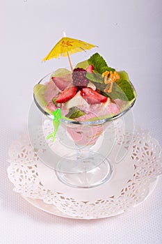 Fruit dessert with cream, mint, fresh fruit in glass bowl