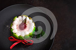 Fruit dessert tart with whipped sweet curd cream and with sweet cherry on top. Old black background. Close-up. Top view photo