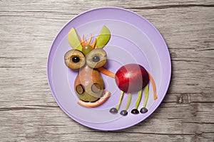 Fruit donkey on purple plate and wooden background