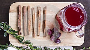 Fruit drink with cinnamon and herbs on chopping board flat lay
