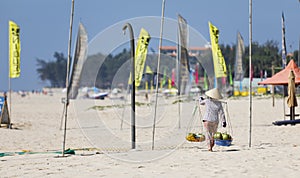 Fruit and drink seller walk in a beach in Nam Tien, Vietnam