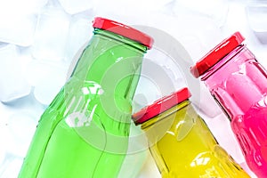Fruit drinks in colorful plastic bottles with ice top view mock-up