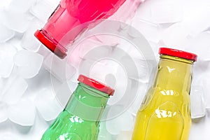 Fruit drinks in colorful plastic bottles with ice top view mock-up