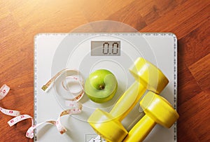 Fruit, dumbbell and scale, fat burn and weight loss concept