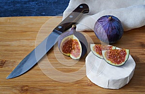 Fruit of figs, cheese Bree and a knife on a bamboo board