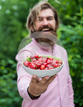 fruit full of vitamins. healthy food and eating. dieting concept. mature brutal hipster with red berry bowl. natural and