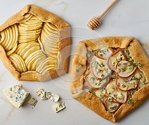 Fruit galette, apple pie with honey, savory pear and cheese pie, marble table, top view